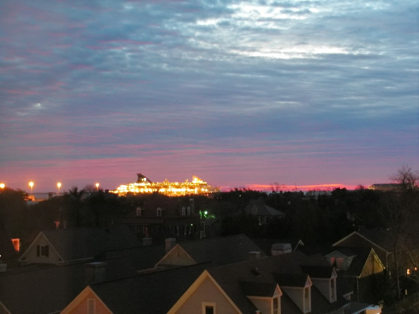 Norwegian Majesty at dock across Charleston, SC night time skyline.